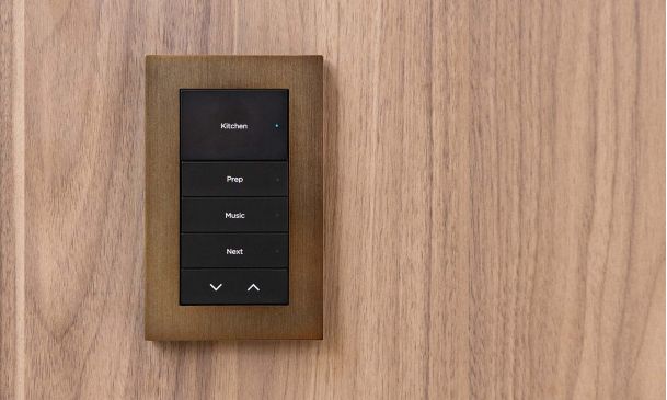 Close up shot of a lux lighting keypad on wood grain background from Control4
