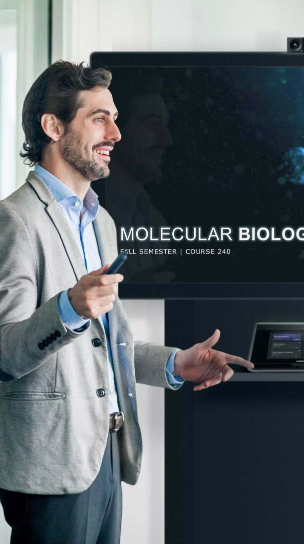Man standing at computer screen while teaching a biology class