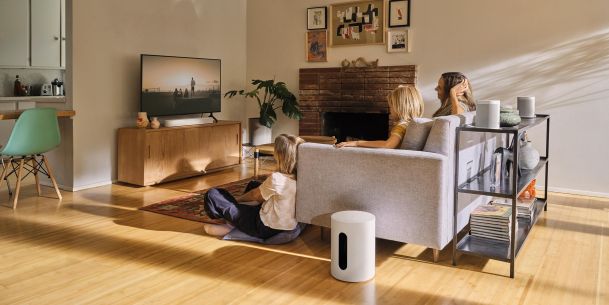 Family watching TV with Sonos speakers in the foreground